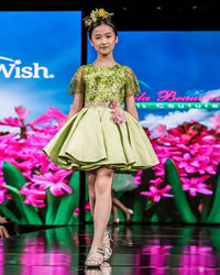 Portrait of a smiling girl standing against pink flowers