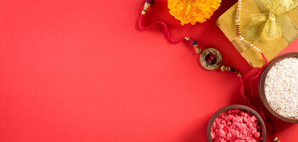 High angle view of pink petals on red background