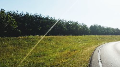 Scenic view of grassy field against clear sky