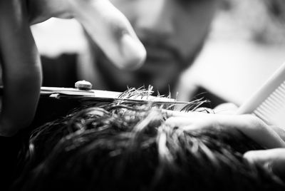 Close-up of barber cutting customer hair