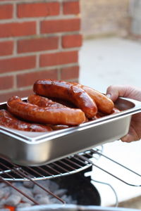 Close-up of man preparing food on barbecue grill