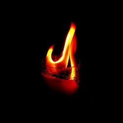 Close-up of illuminated lamp over black background