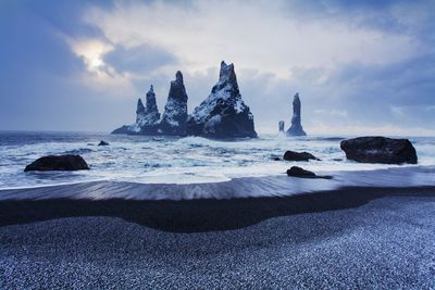 Rocks on beach against sky