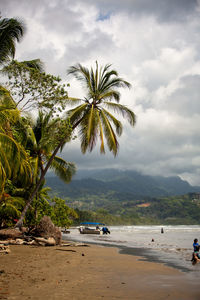 People at beach against sky