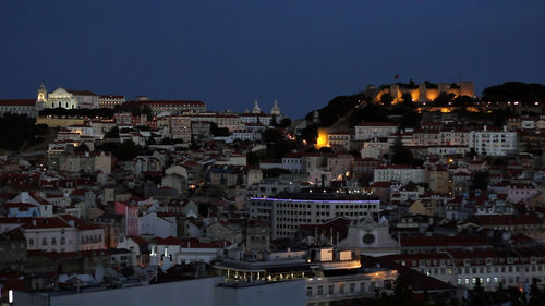 Illuminated cityscape against clear sky at dusk