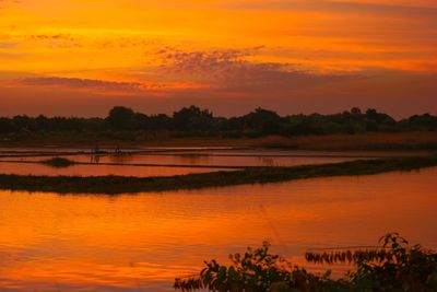 Scenic view of lake against romantic sky at sunset