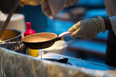 Making morning breakfast and placing omelets on the pan. wearing white gloves.