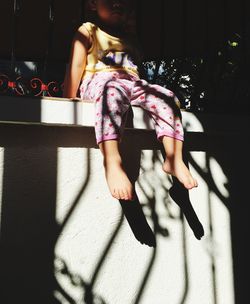 Girl sitting on retaining wall