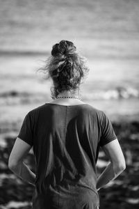 Rear view of woman standing at beach