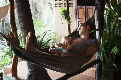 Father with baby seeping on hammock, thailand