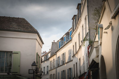 Low angle view of buildings in town against sky