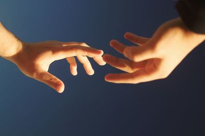 Close-up of hand touching light over black background