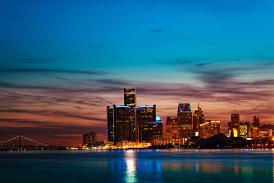 Illuminated buildings in city against sky at night