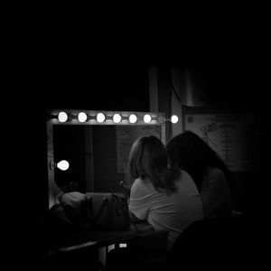 Rear view of couple sitting in illuminated room