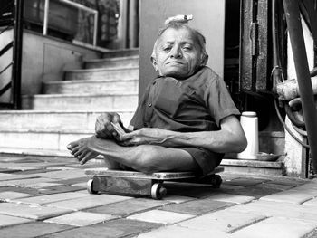 Portrait of disabled man sitting on footpath