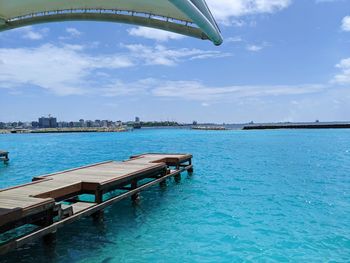 View of swimming pool in sea against cloudy sky