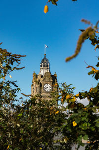 Low angle view of clock tower against blue sky