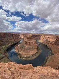 Rock formations on landscape against cloudy sky