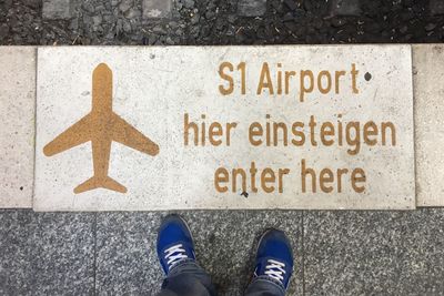 Low section of man standing by information sign