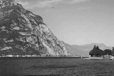 Scenic view of sea by mountains against sky