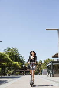 Young woman with e-scooter in the city