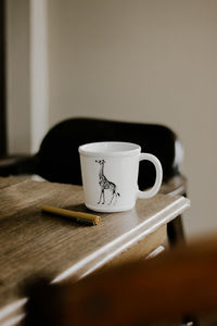 Close-up of white mug on wooden table