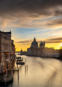 View of buildings at waterfront against cloudy sky