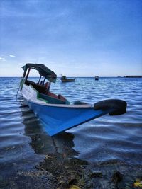 Boat moored on sea against sky