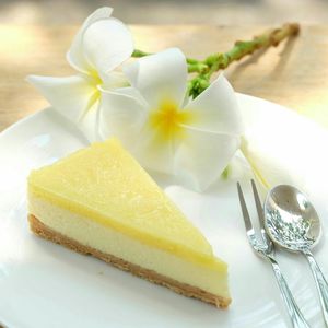 Close-up of lemon meringue pie and frangipanis on plate