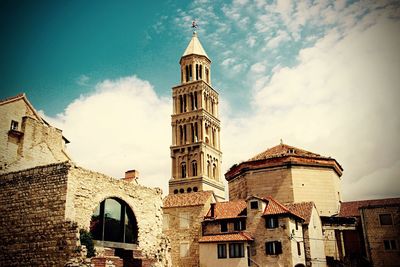 Low angle view of bell tower against cloudy sky