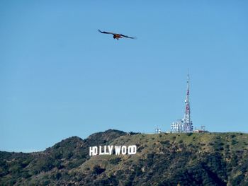 Low angle view of airplane flying against clear blue sky