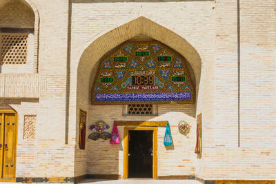 Low angle view of cross on wall of building