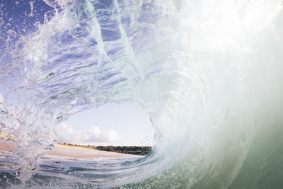 Sea waves flowing against sky