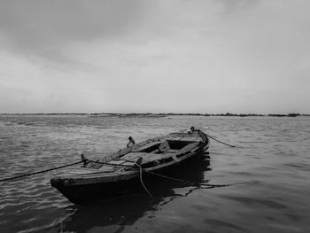 Fishing boat in sea against sky