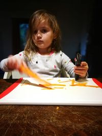Portrait of cute girl holding table