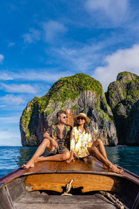 Woman sitting on boat in sea against sky