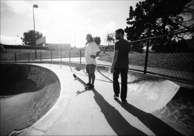 Rear view of man skateboarding on skateboard against sky