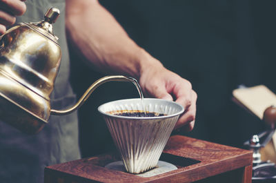 Cropped image of hand pouring coffee cup