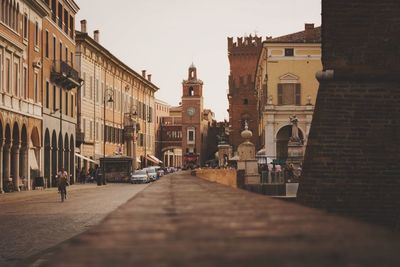 People on street by buildings in city