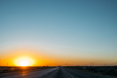 Road against clear sky at sunset