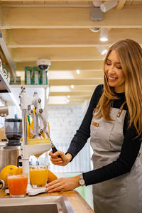 Portrait of smiling young woman sitting in kitchen