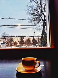 Close-up of coffee cup on table against window