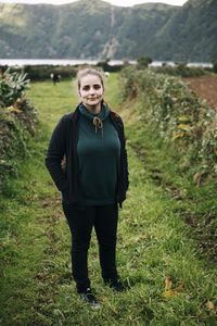 Portrait of young woman standing on field