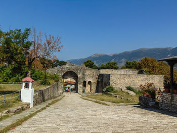 Footpath amidst buildings against sky