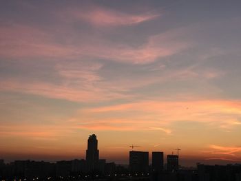 Silhouette buildings against sky during sunset