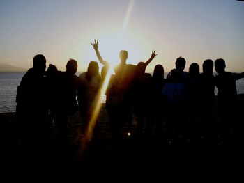 Silhouette people enjoying at sunset