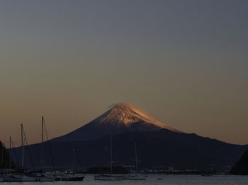 Scenic view of snowcapped mountains against clear sky during sunset