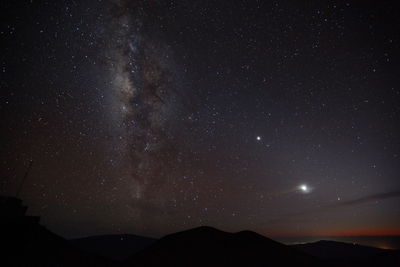 Scenic view of silhouette mountain against star field at night