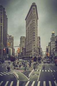 View of city street and flat iron building in new york against sky