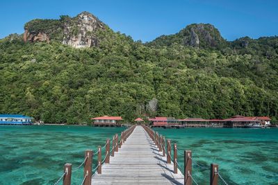 Scenic view of pier and mountains against sky